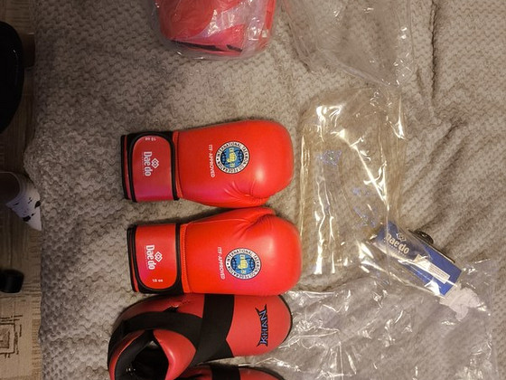 Müün kindaid, kiivrit, jalanõusid ja taekwondo ülikonda.